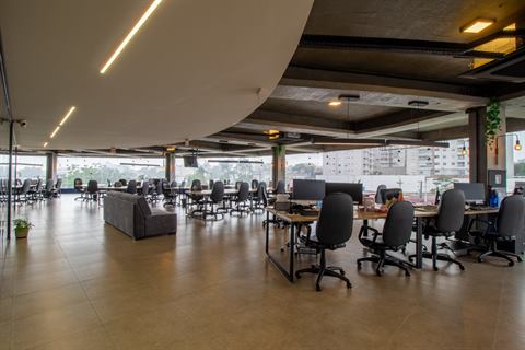 Open space com estações de trabalho e janelas para a cidade